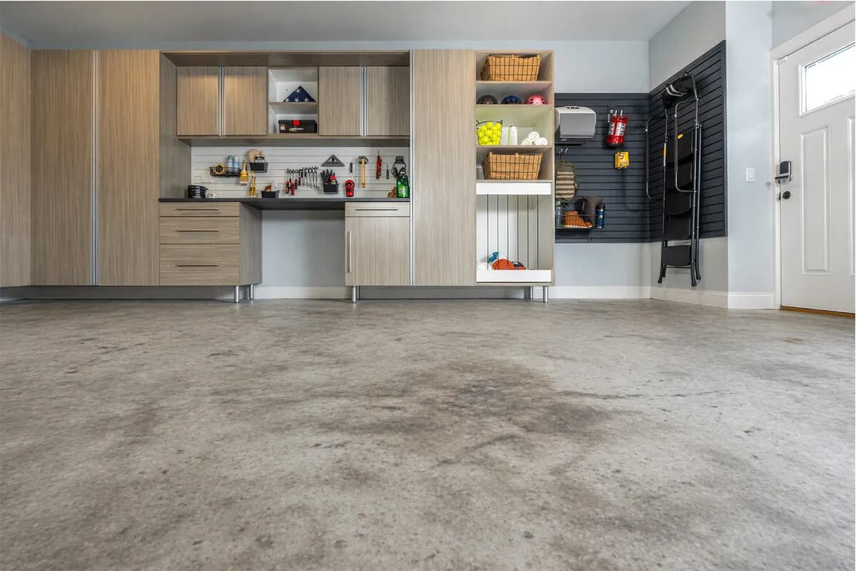 Modern garage interior with organized storage, countertops, and concrete flooring.