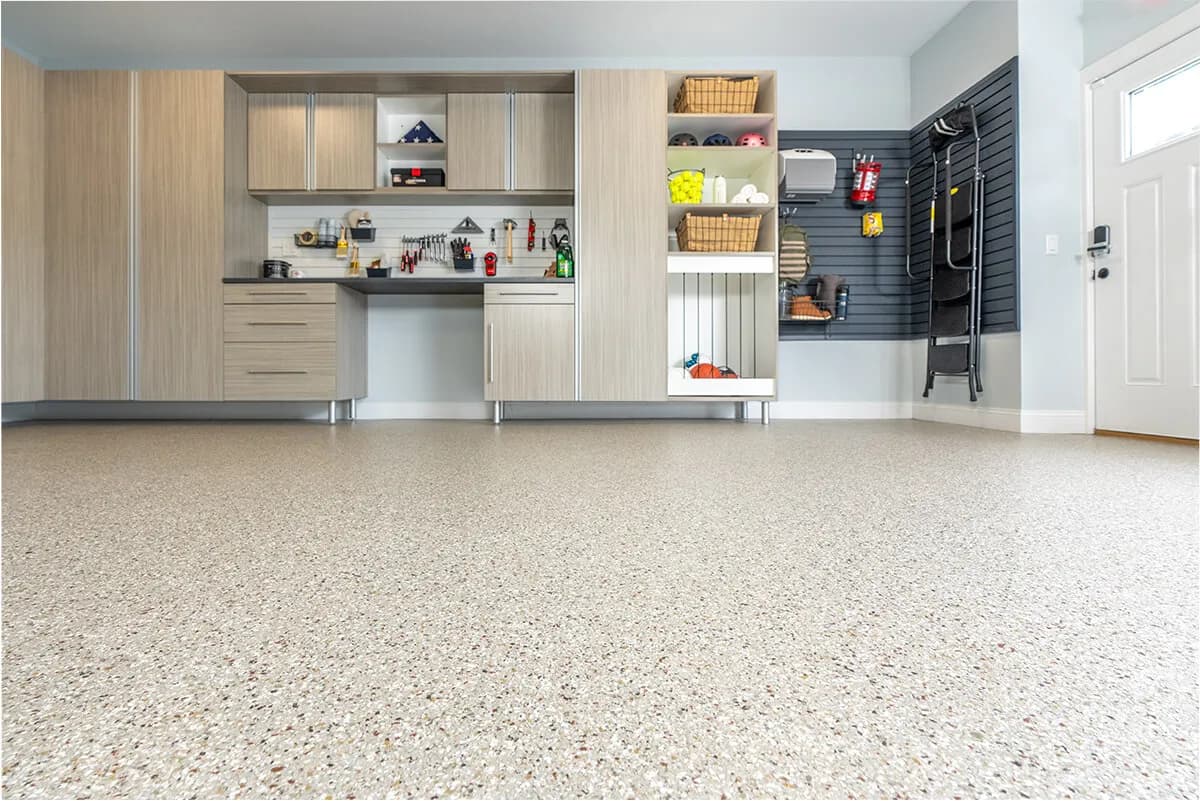 Modern garage interior with organized storage, beige floor, and wall-mounted tools.